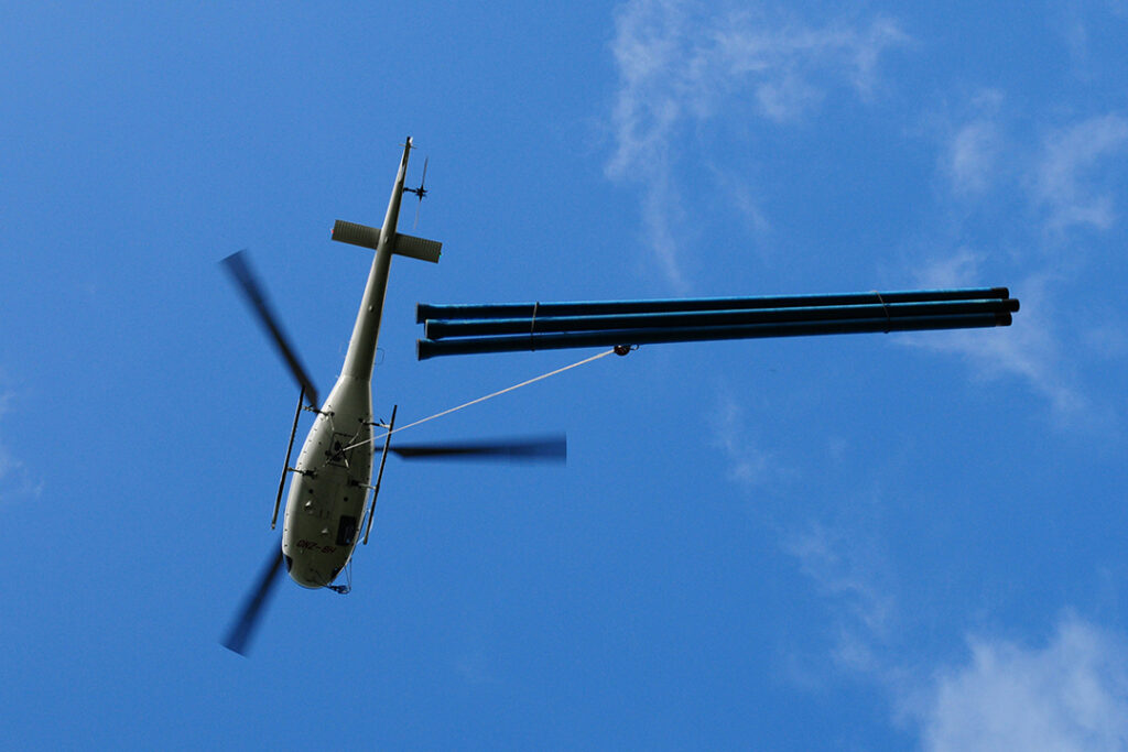 A Swiss helicopter hauling pipeline construction materials