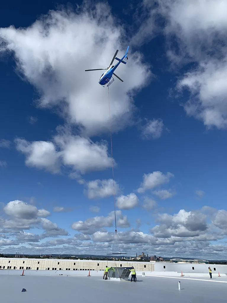 The Airbus H125 placing the rooftop HVAC equipment.