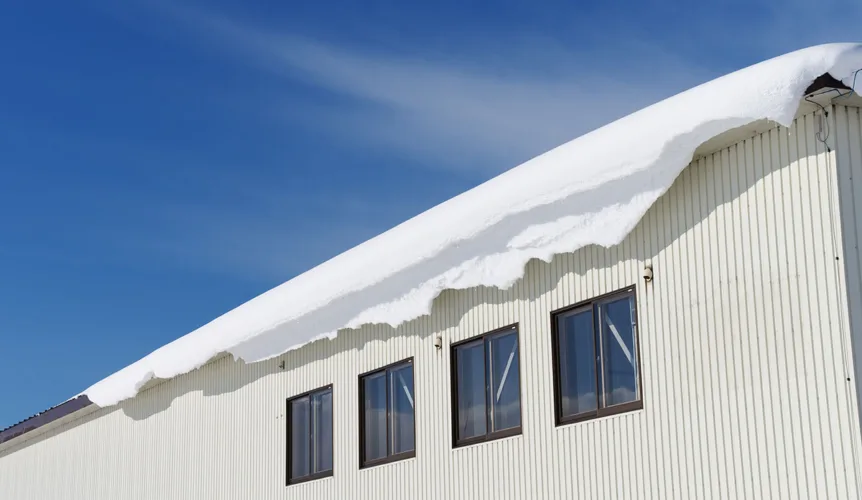 Heavy snow on warehouse roof.