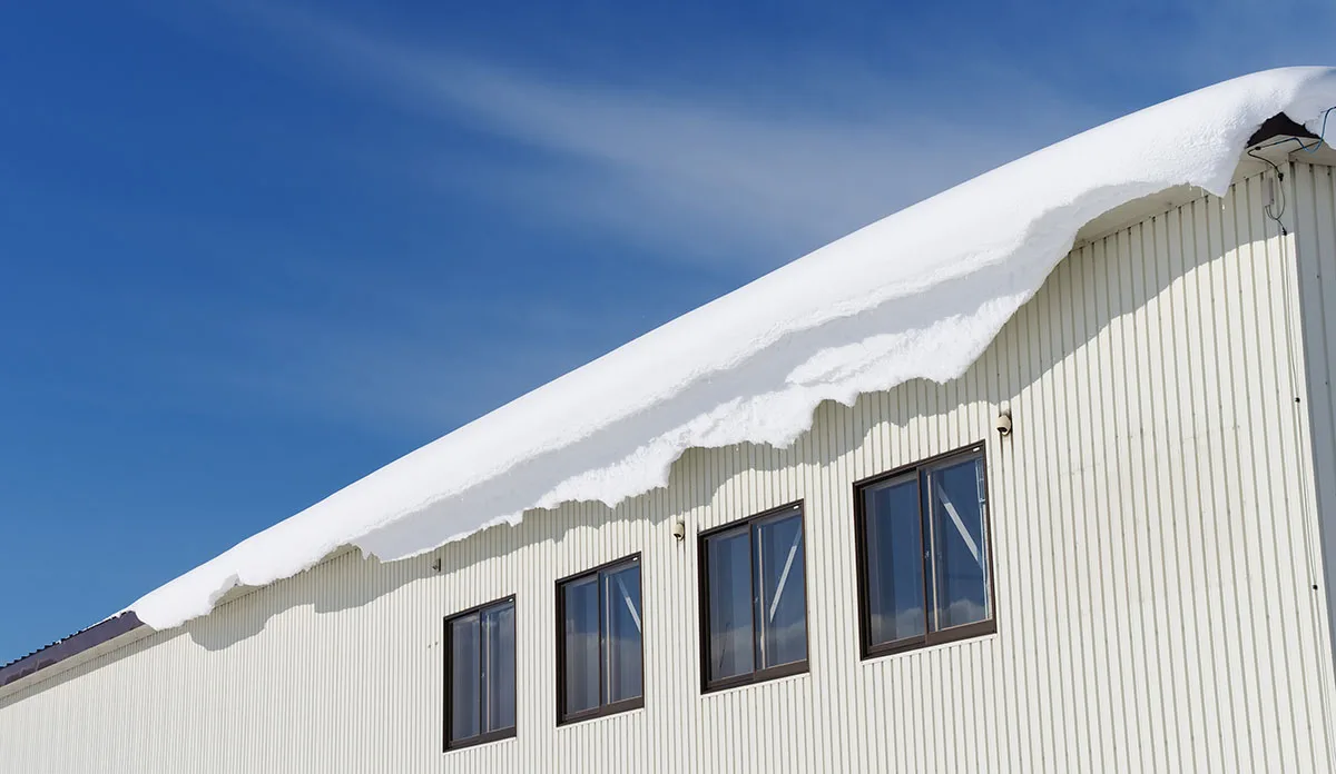 Heavy snow on warehouse roof.
