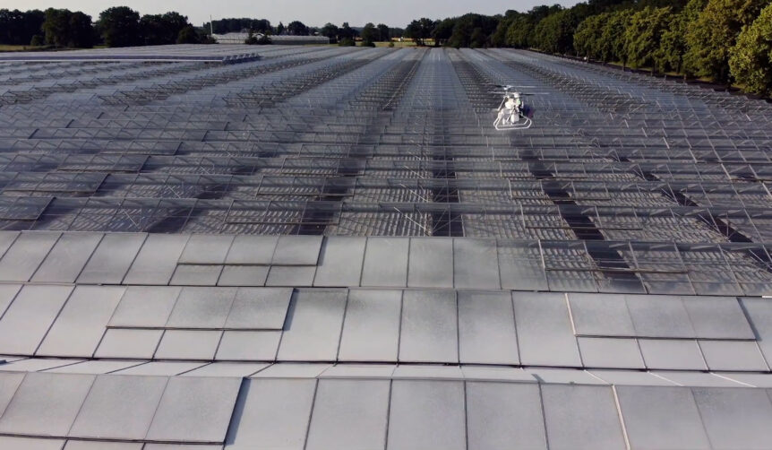 An XAG V40 drone coating a greenhouse with shading agent.