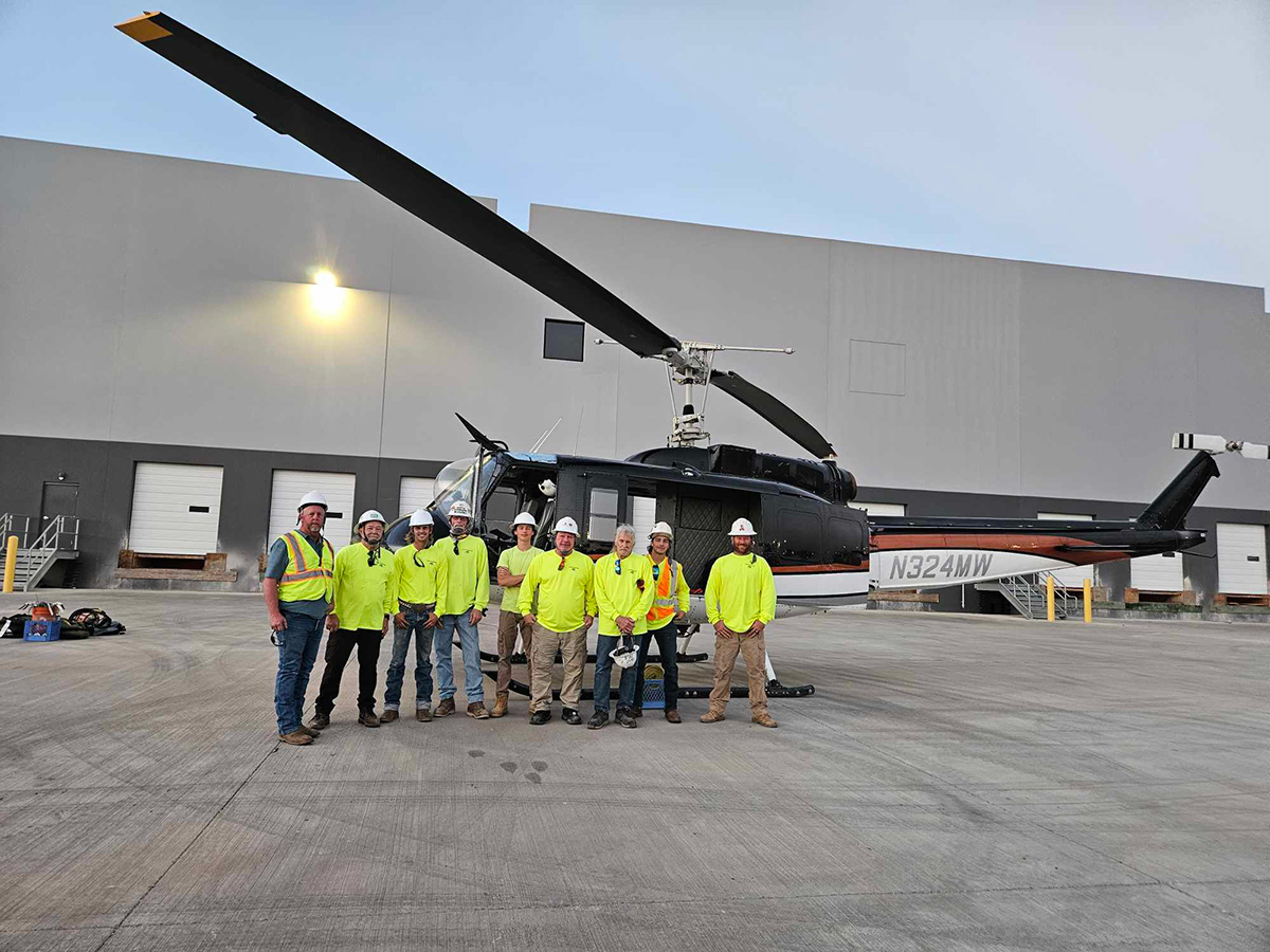 Lift crew standing in front of the 1965 BELL UH-1H helicopter during the 52-unit warehouse project in Glendale, AZ