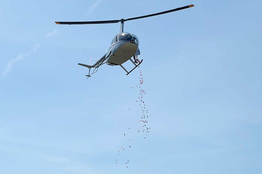 A Robinson R66 dropping 30,000 Easter Eggs at Believers Baptist Church