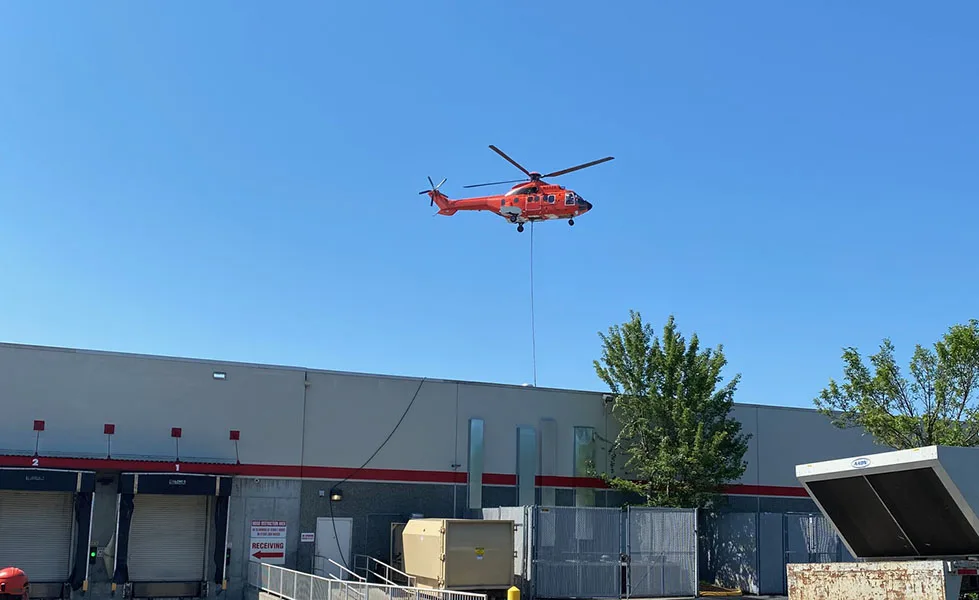 The AS332L1 Super Puma at Work Placing HVAC Units.