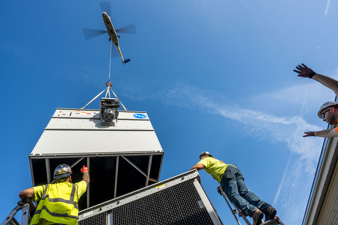 An HVAC unit being placed on a roof top.