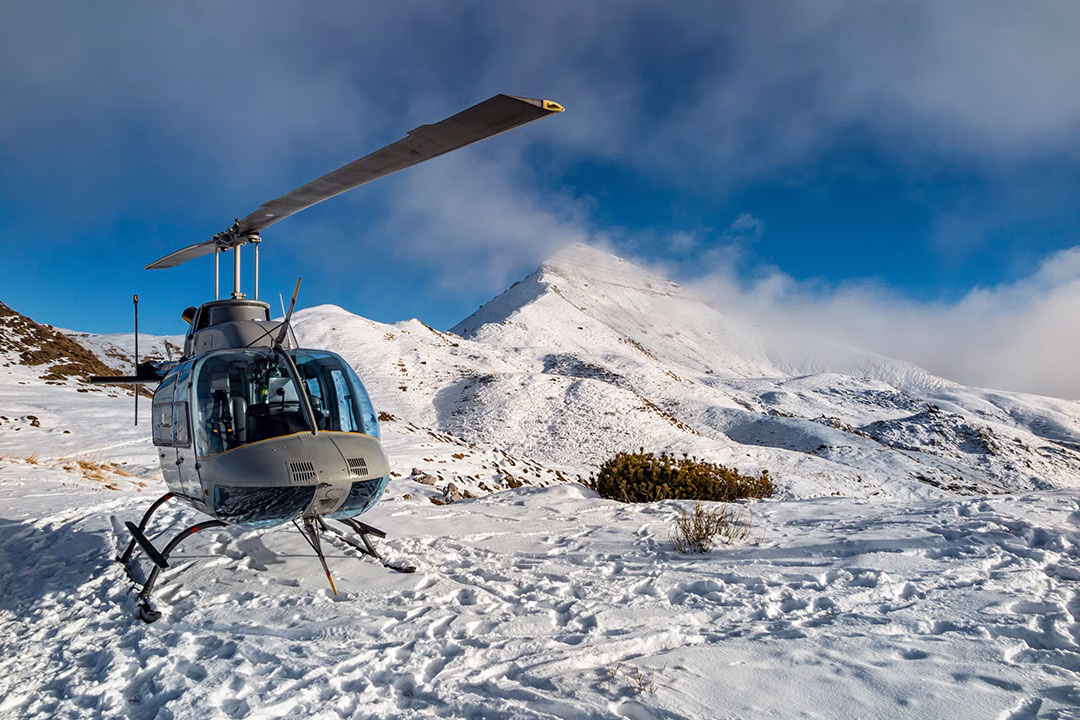 A helicopter sits atop the Italian Alps.