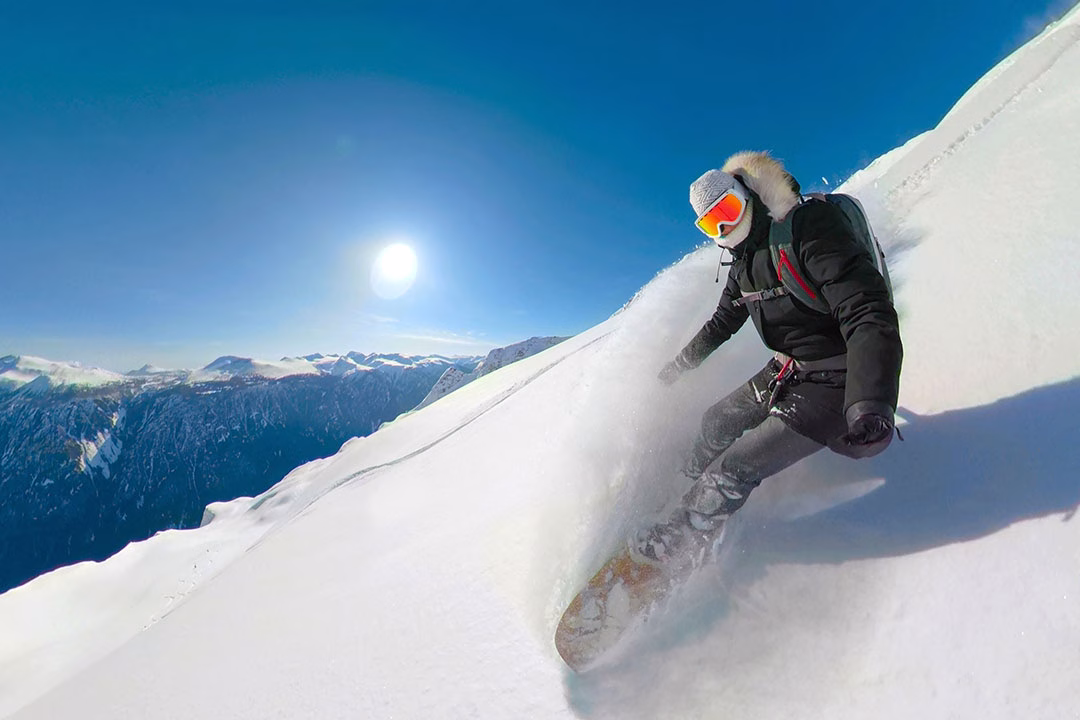 Female heliboarder enjoying her winter holidays in the pristine mountains of British Columbia.