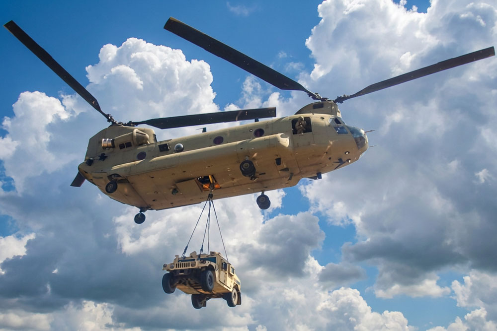 Boeing CH-47 Chinook lifting a military Humvee as an external sling load
