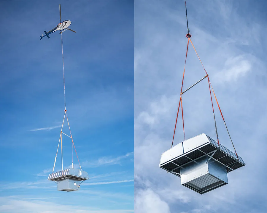 An HVAC Rooftop Unit hangs from a helicopter crane.