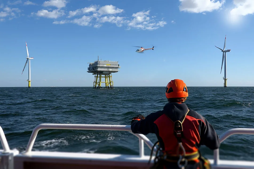 A helicopter flies to an offshore wind farm providing transportation to the turbines.