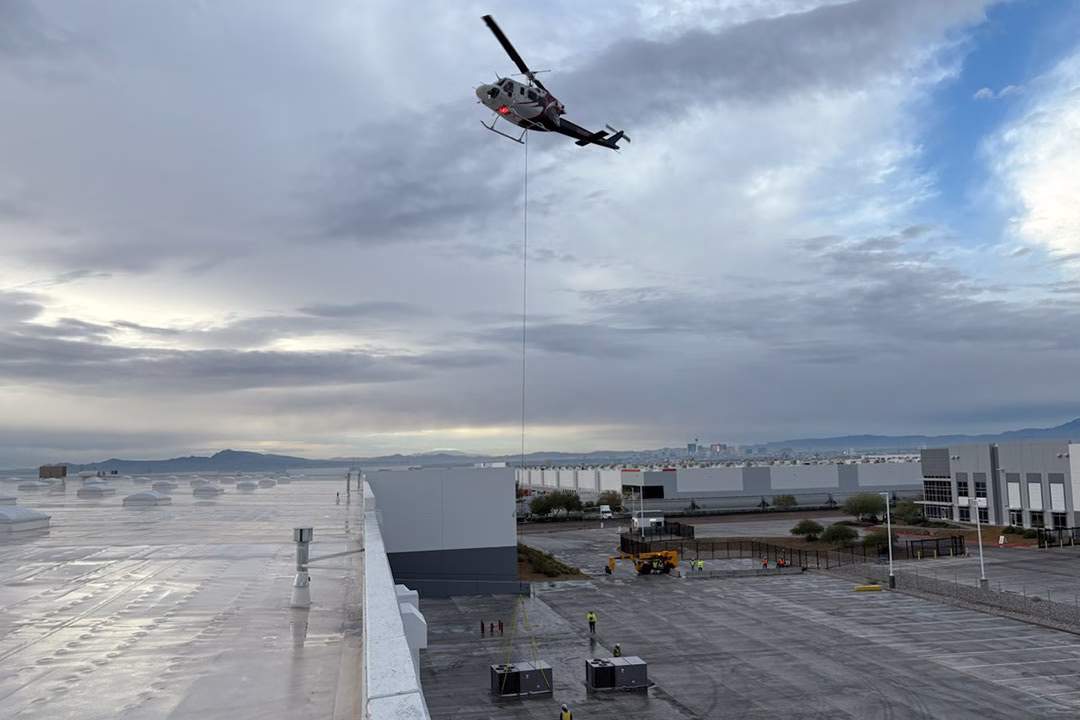 The Bell 212 setting up to lift a rooftop unit from the staging area.