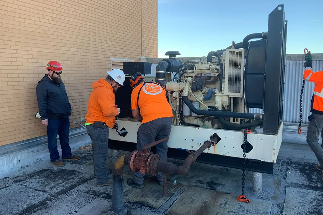 The lift crew preps the original HVAC unit for removal.