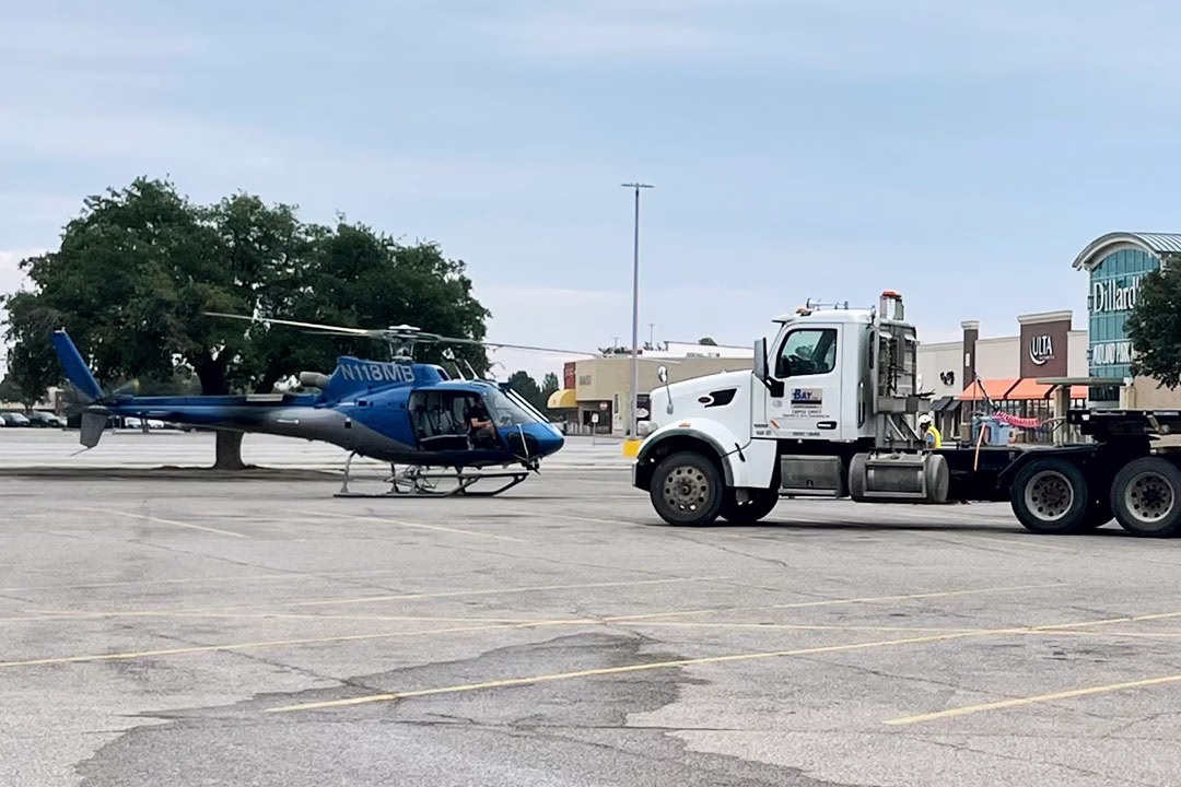 The lift helicopter sits in the staging area with the HVAC unit delivery truck.