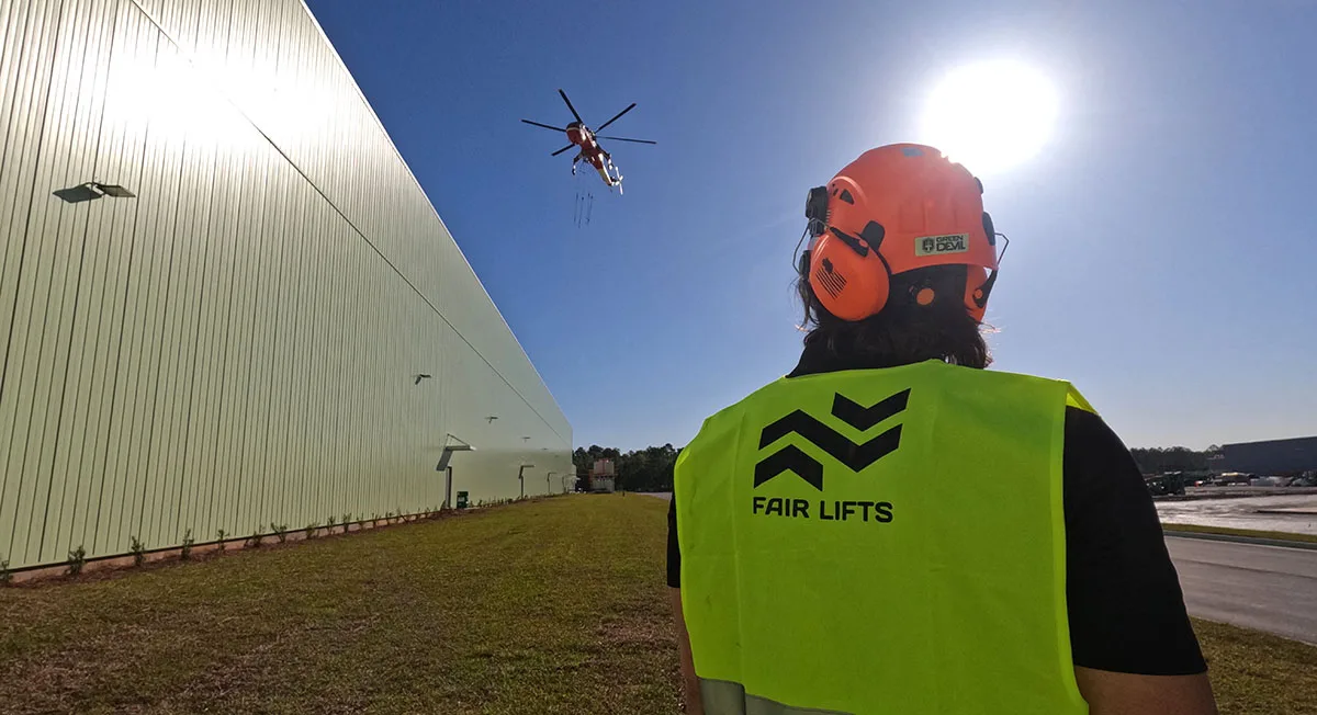 A Fair Lifts project manager monitors a Sikorsky S-64 Skycrane heavy lift operation on an active job site.