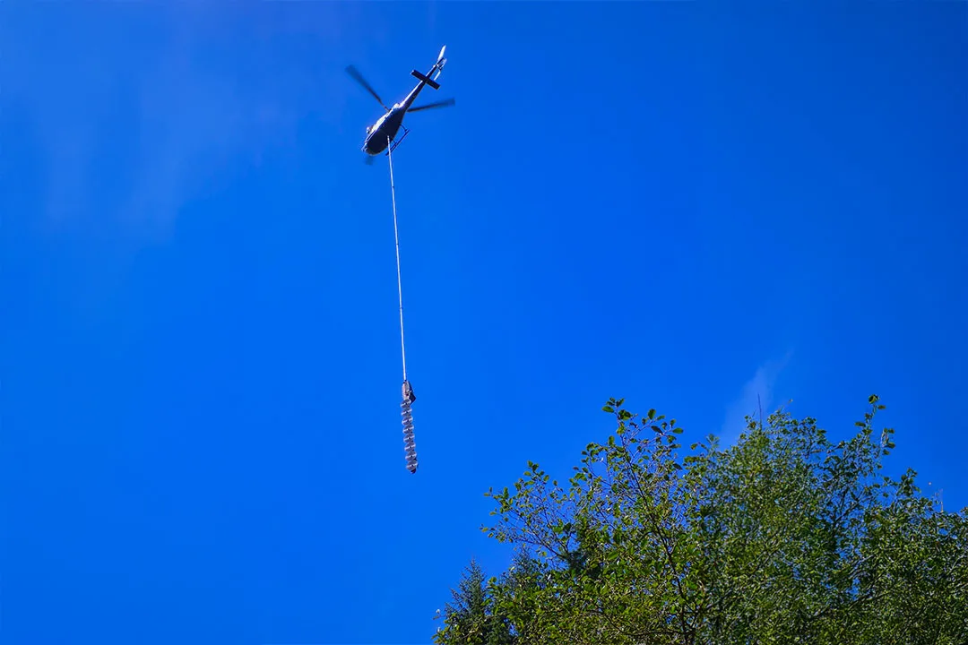 Forestry helicopter with spinning blade suspended saw