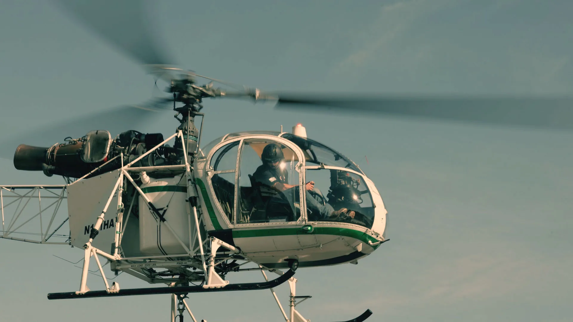 A close up view of an Aérospatiale SA 315B Lama helicopter pilot navigating a lift.